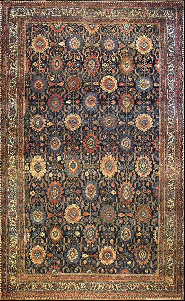 Navy rug featuring intricate repeating medallions and boteh in contrasting cream, rust, and teal colors.