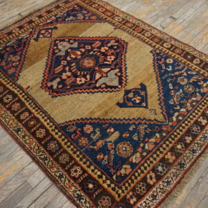 Geometric brown, navy, and rust-colored rug with a central design resting on distressed wood flooring.