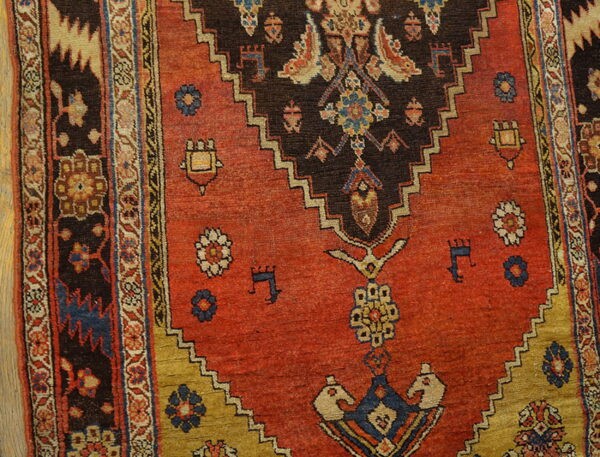 Low-pile rug featuring a rust red field, dark brown stepped medallion, and intricate geometric and floral borders.
