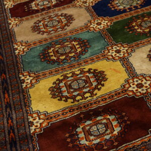 High-pile rug featuring a geometric block pattern in gold, teal, deep red, navy, and tan.