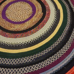 Colorful braided circular rug with rings of multicolored, textured stripes in varying widths.