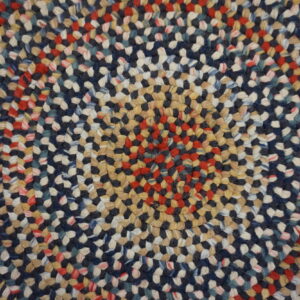Tightly braided multicolor rug texture with concentric rings of navy, red, cream, and tan fibers.