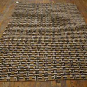 Flatweave rug featuring thick black, cream, and khaki rectangular geometric blocks on wood flooring.