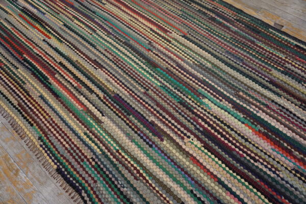 Textured, low-pile rug with variegated diagonal stripes of small braided loops in multiple earthy colors.