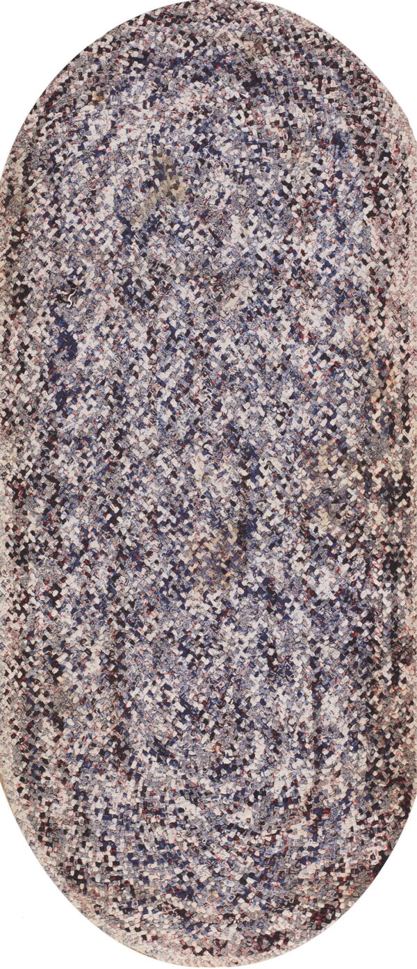 A braided oval runner rug in mottled shades of blue, gray, white, and red.