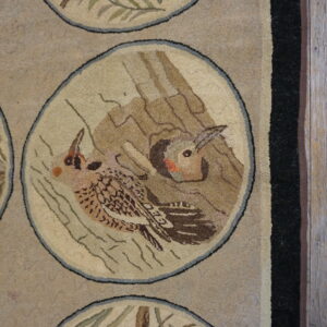 Beige hooked rug with circular wildlife medallions, including brown birds, green foliage, and black borders.