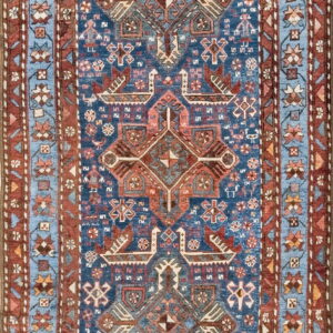 Deep blue runner rug with complex geometric patterns in terracotta, powder blue, and cream.