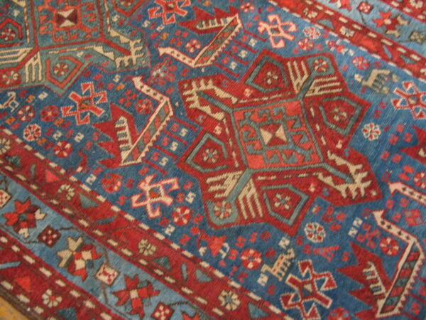 Geometric rug detail showing a pattern of large red, blue, and tan tribal medallions.