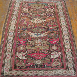 Geometric runner rug with deep red, black, teal, and beige tribal patterns on polished hardwood.
