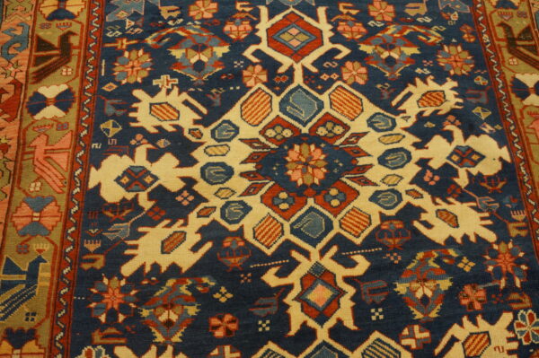 Geometric rug detail showing large cream motifs against a navy field with red, rust, and blue accents.