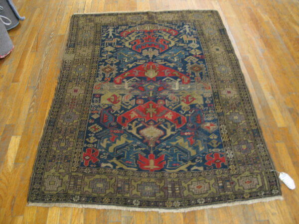 Geometric rug in blue, red, and khaki on shiny light brown hardwood flooring.