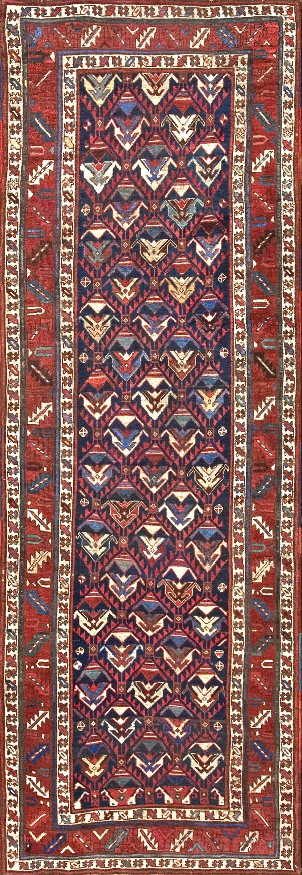 Dark blue rug with stylized geometric motifs and multiple red borders featuring tribal elements.