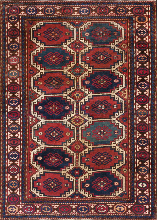 Geometric rug with stepped panels in deep red and navy blue, bordered by small octagonal motifs.