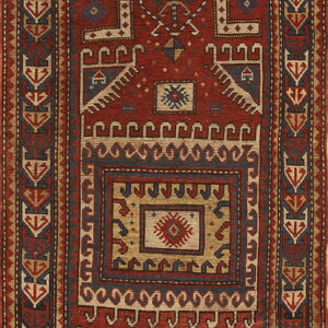 Red and blue tribal rug with geometric patterns, central stepped medallion, and intricate stacked borders.
