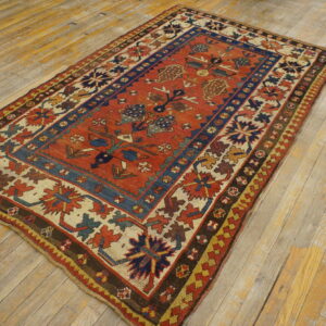 A tribal-patterned rug featuring rust red, navy blue, and cream sits on distressed wood planks.