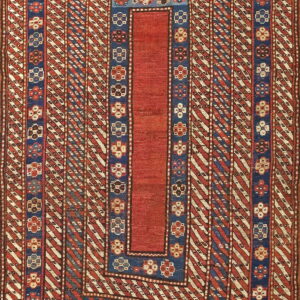 Low-pile geometric rug featuring a red center, flanked by blue borders and red and cream diagonal stripes.