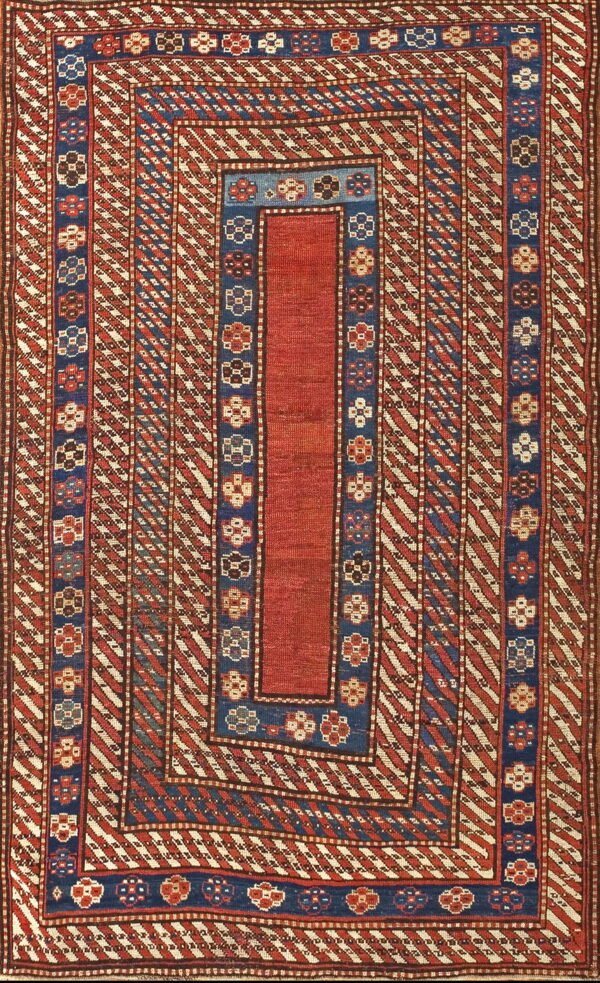 Low-pile geometric rug featuring a red center, flanked by blue borders and red and cream diagonal stripes.