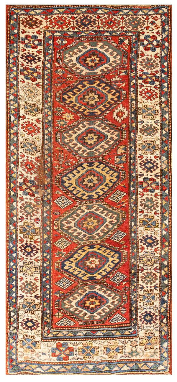 Low-pile red runner rug featuring stacked geometric medallions in blue, cream, gold, and visible patina.