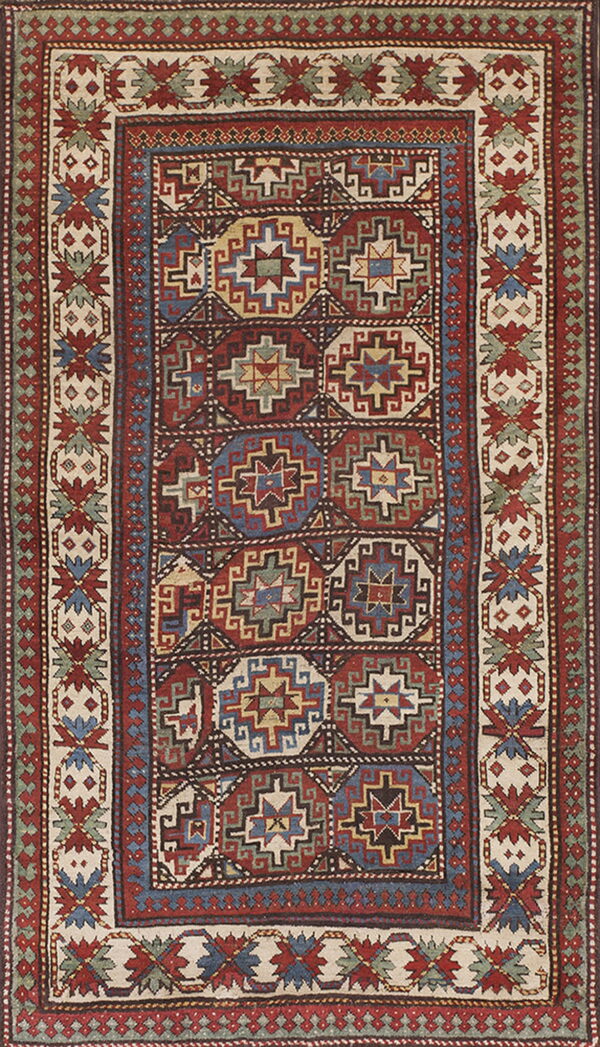Geometric short-pile rug with repeating octagonal medallions surrounded by complex borders in red, blue, and cream.