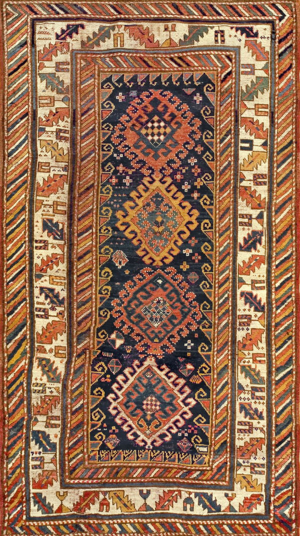 Detailed geometric rug with a navy field, rust medallions, and multi-layered borders in cream, blue, and gold.