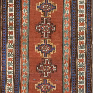 Flat-weave rug with a rust field, featuring stacked blue geometric motifs and elaborate teal and brown borders.
