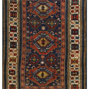 Low pile rug featuring a dark blue field with intricate red, blue, and cream geometric tribal patterns.