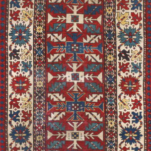 Geometric runner rug featuring a red center field framed by cream borders with stylized blue, red, and yellow motifs.
