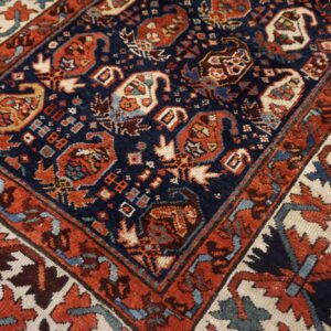 High-pile rug detail in navy, rust, and cream, featuring intricate geometric and stylized paisley designs.