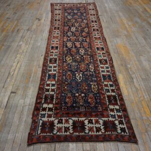 Traditional navy runner rug with red and cream geometric patterns on distressed wood planks.