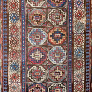 A geometrically patterned rug featuring columns of multicolored octagonal medallions and intricate blue and red borders.