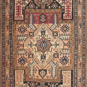 Intricate geometric rug featuring a central medallion in navy, cream, burgundy, and dusty rose tones.