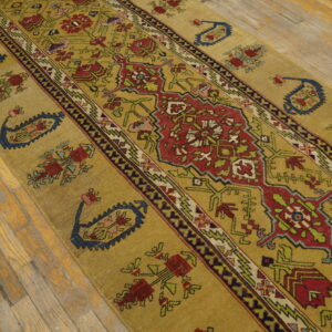Gold runner rug featuring tribal red, navy, and green geometric patterns on distressed hardwood.