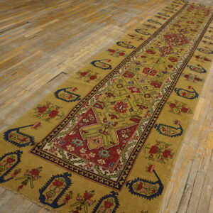 Gold and red traditional runner rug with a geometric pattern lies on rustic wooden flooring.
