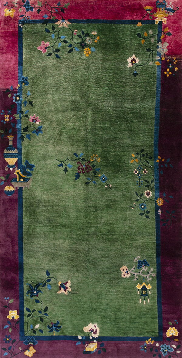 Lush green pile rug with magenta and plum borders decorated with colorful floral and vessel designs.