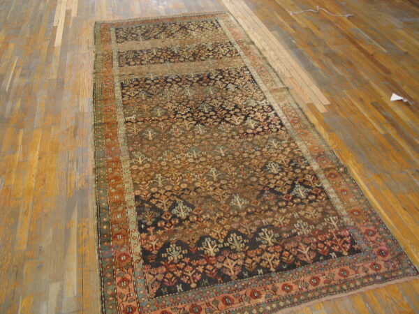 Multi-toned runner rug with repeating stylized trees and horizontal color bands sits on worn wood planks.