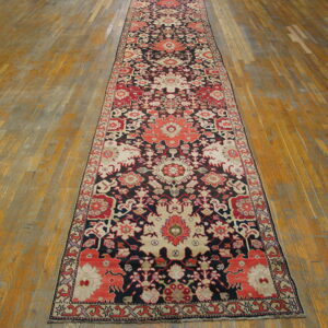 Traditional floral runner in navy, coral, and cream colors stretching across a distressed wooden floor.