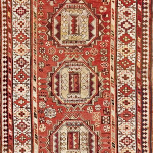Rust and cream rug with a geometric pattern of repeating octagonal medallions and multiple ornate borders.
