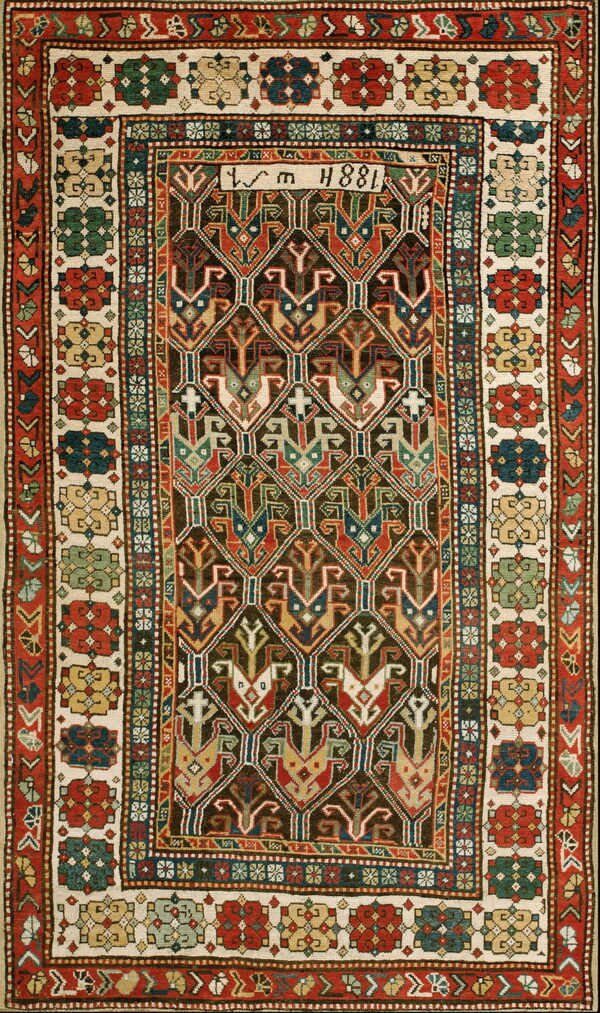 A complex rug featuring dark brown, red, and blue geometric motifs enclosed by multicolored floral borders on cream.