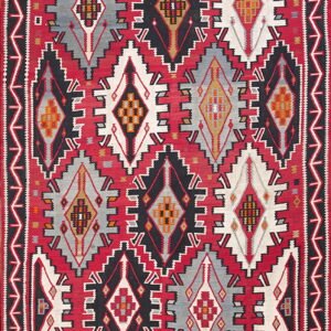Geometric flatweave rug featuring large, stepped diamond medallions in red, black, white, gray, and orange accents.