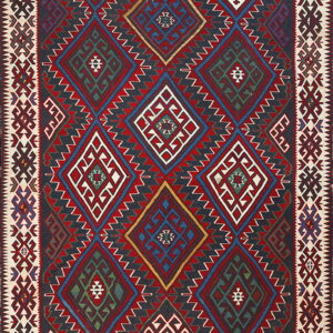 Multicolored flatweave rug featuring interlocking geometric diamonds in red, navy, white, and green.