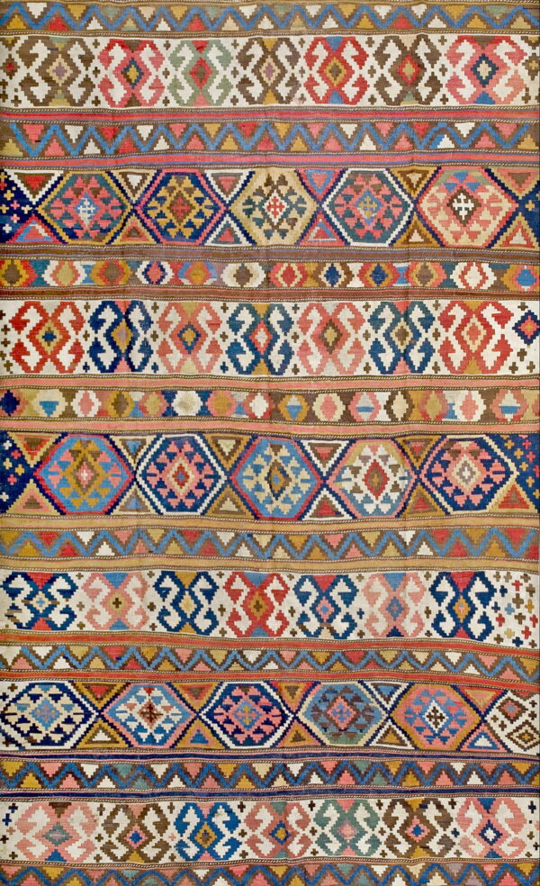 Flatweave rug with multicolor geometric patterns, including diamonds and zigzags, across horizontal stripes.