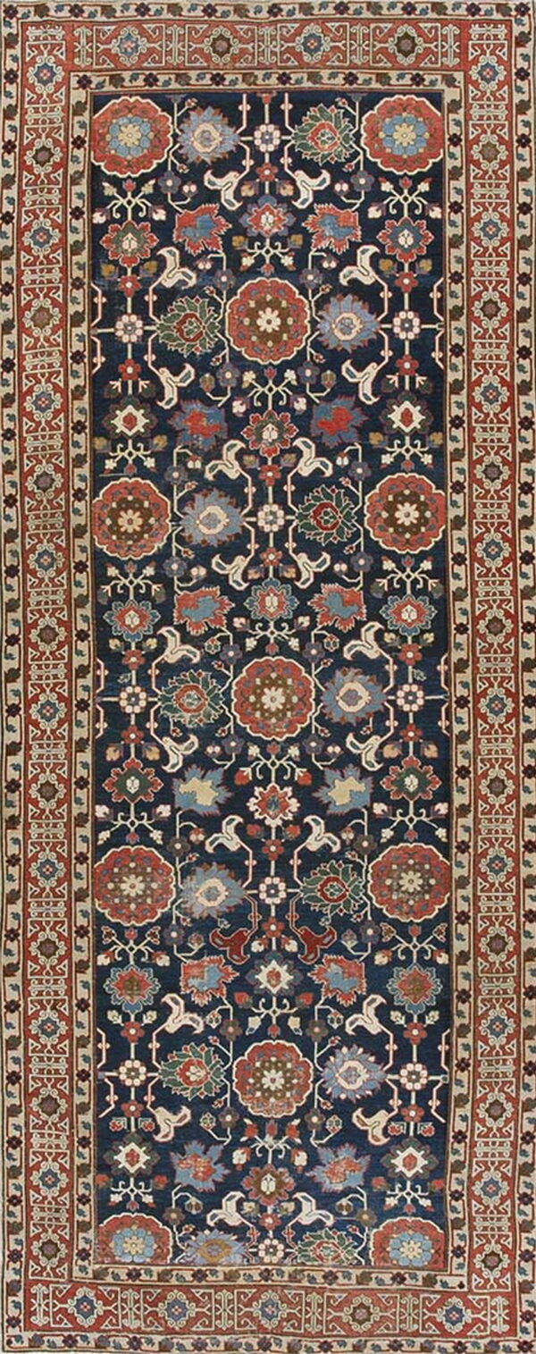 Navy blue traditional runner rug featuring detailed rust, light blue, and green floral medallions and geometric borders.