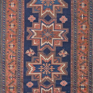 Navy blue runner rug with alternating geometric star patterns and thick borders in red-orange.