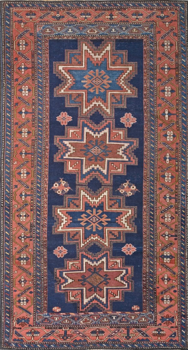 Navy blue runner rug with alternating geometric star patterns and thick borders in red-orange.