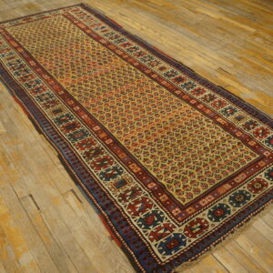 Runner rug with red, blue, and yellow geometric patterns displayed on rustic, wide plank wood flooring.