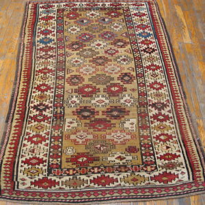 Narrow runner rug with a tan field and intense red, cream, blue, and brown geometric tribal patterns on wood floor.