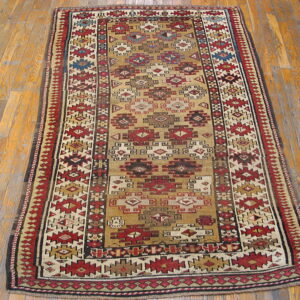 Geometric runner rug featuring complex red, tan, and dark brown motifs on wood planks.