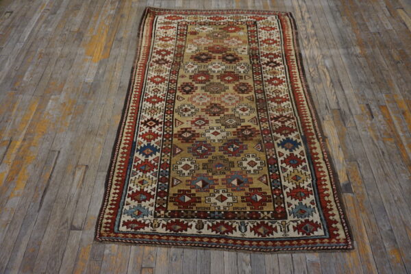 Geometric runner rug in gold, red, blue, and cream colors on distressed wood flooring.