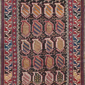 Dark field rug with red, blue, and gold geometric medallions and wide, complex red borders.