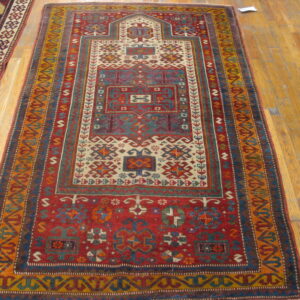 Geometric red runner with ivory, blue, and gold tribal patterns rests on light hardwood planks.